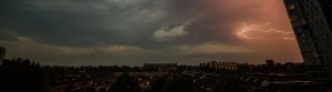 stormy evening sky with subtle sunlight on top of a city for climate adaptation media feature page