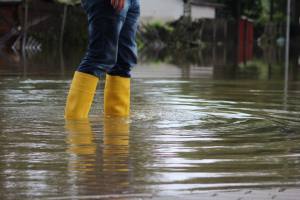 person in rain boots walking in flooded area