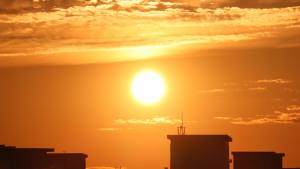 Bright orange sun over a city